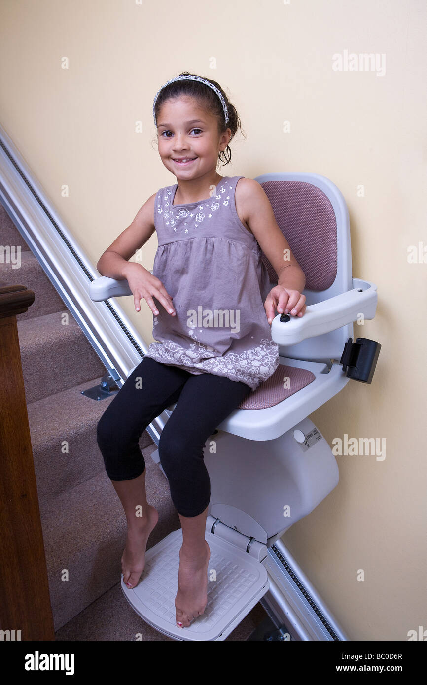 Une jeune fille a de grands sourires tout en jouant sur son grand grandad's-escalier Banque D'Images