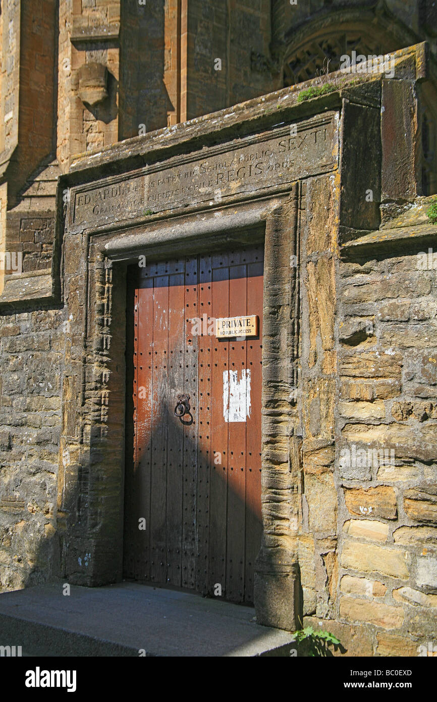 Porte en bois avec inscription latine au-dessus menant à l'école publique de Sherborne Banque D'Images