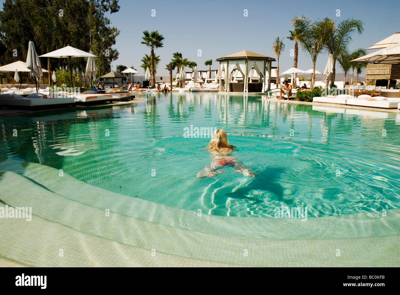 Fille blonde dans la piscine du Nikki Beach de luxe pool bar and resort marrakech maroc afrique du Nord Banque D'Images