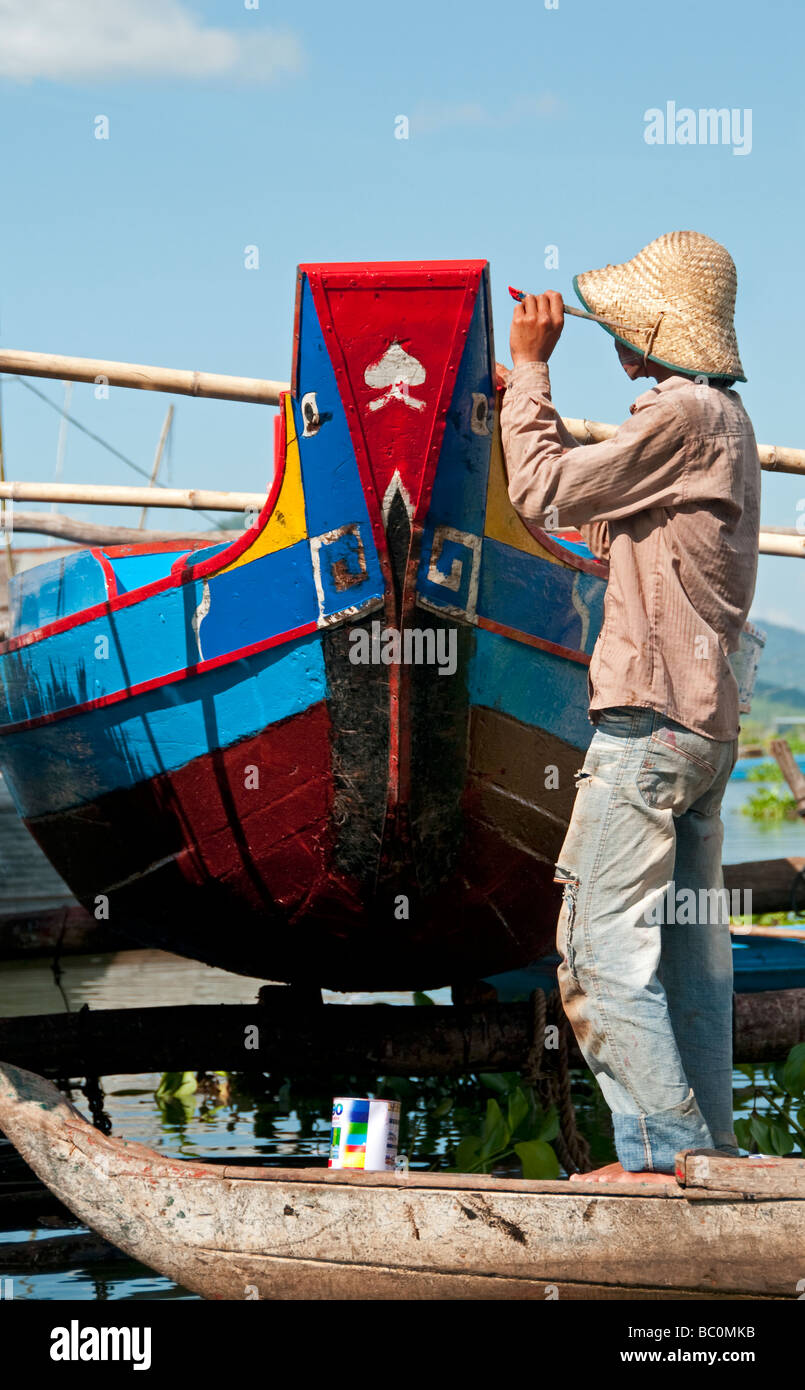 Man painting un bateau à Kompong Chnang, Cambodge Banque D'Images
