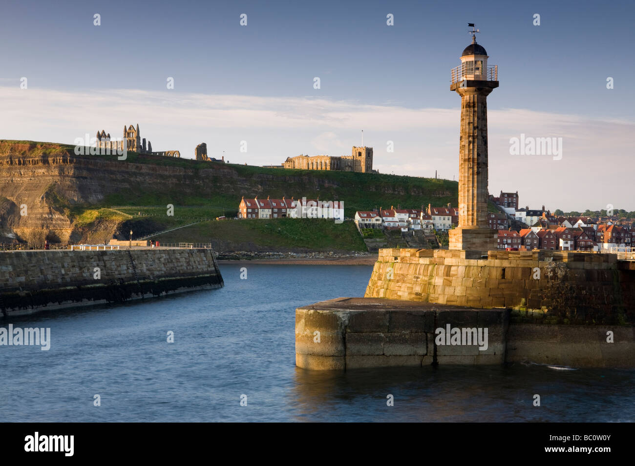 Le phare sur la jetée de Whitby, avec l'abbaye d'Hilda et Eglise St Mary sur les falaises en arrière-plan Banque D'Images