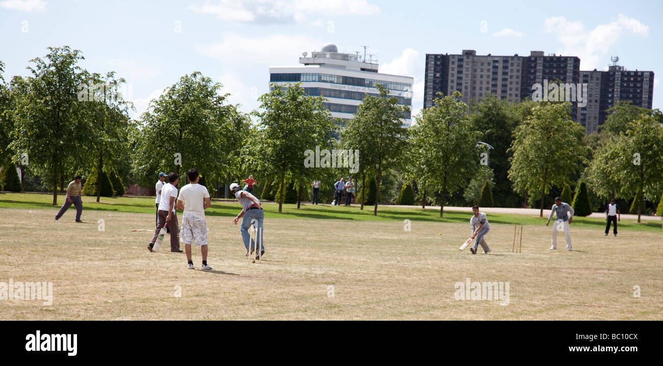 Les jeunes hommes asiatiques jouer au cricket sur Glasgow Green Banque D'Images