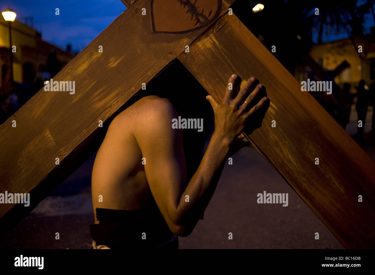 Le pénitent porte une croix lors d'une procession de la semaine sainte à Oaxaca, au Mexique. Banque D'Images