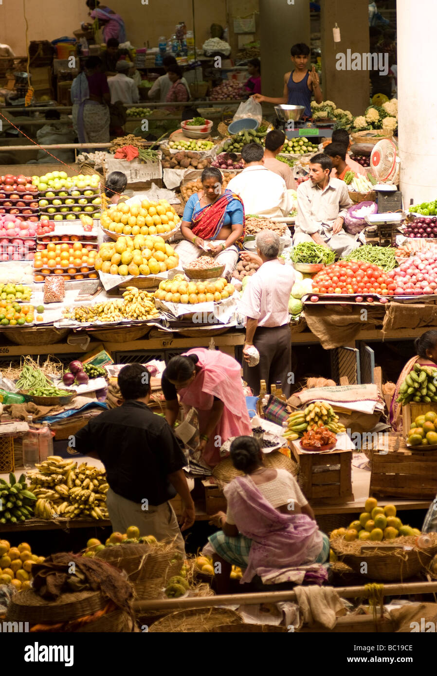 Les commerçants de l'intérieur d'un marché des fruits et légumes Banque D'Images