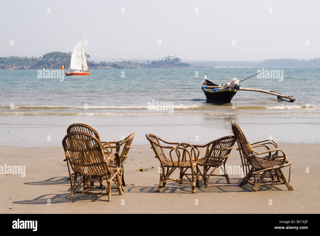 Chaises en osier sur une plage vide. Location de visible dans la distance. Plage de Palolem, Goa, Inde. Banque D'Images