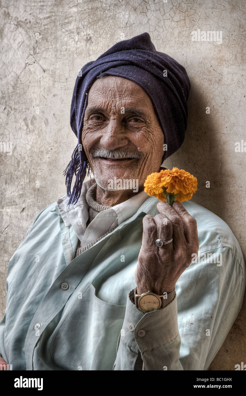 Un vieil homme avec une fleur Banque D'Images