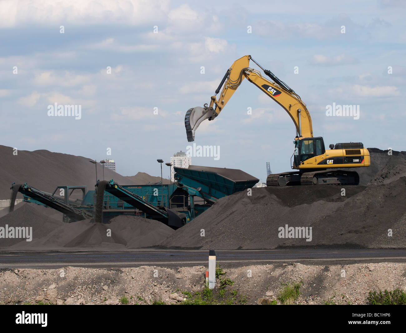 Gros tas de minerai de métal avec pelle caterpillar dans la zone portuaire de Rotterdam Zuid Holland aux Pays-Bas Banque D'Images