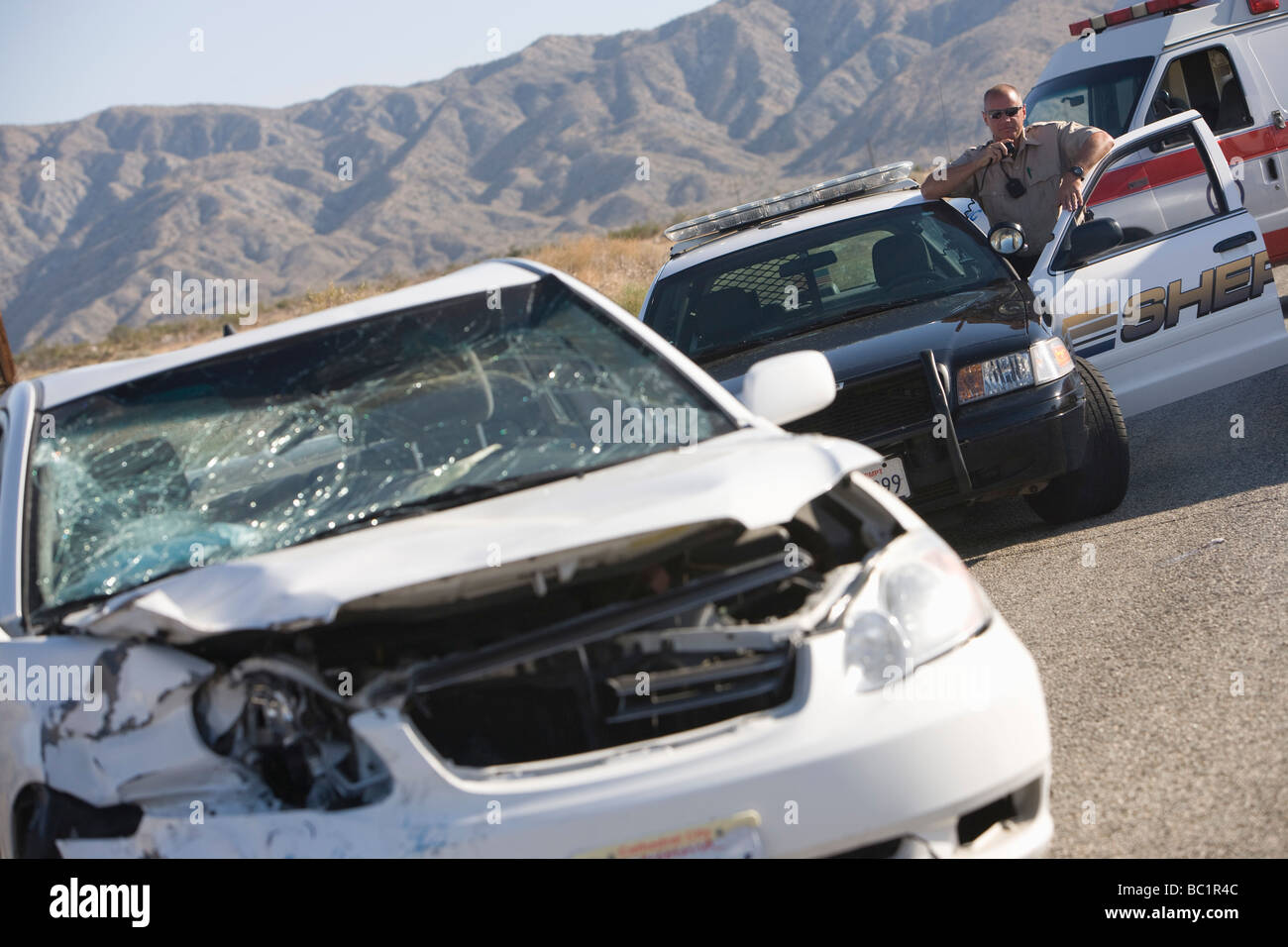 Agent de police arrive sur scène de carcrash Banque D'Images