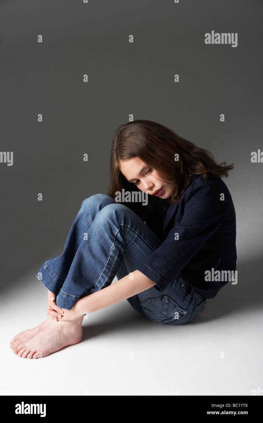 Thoughtful Girl Sitting in Studio Banque D'Images