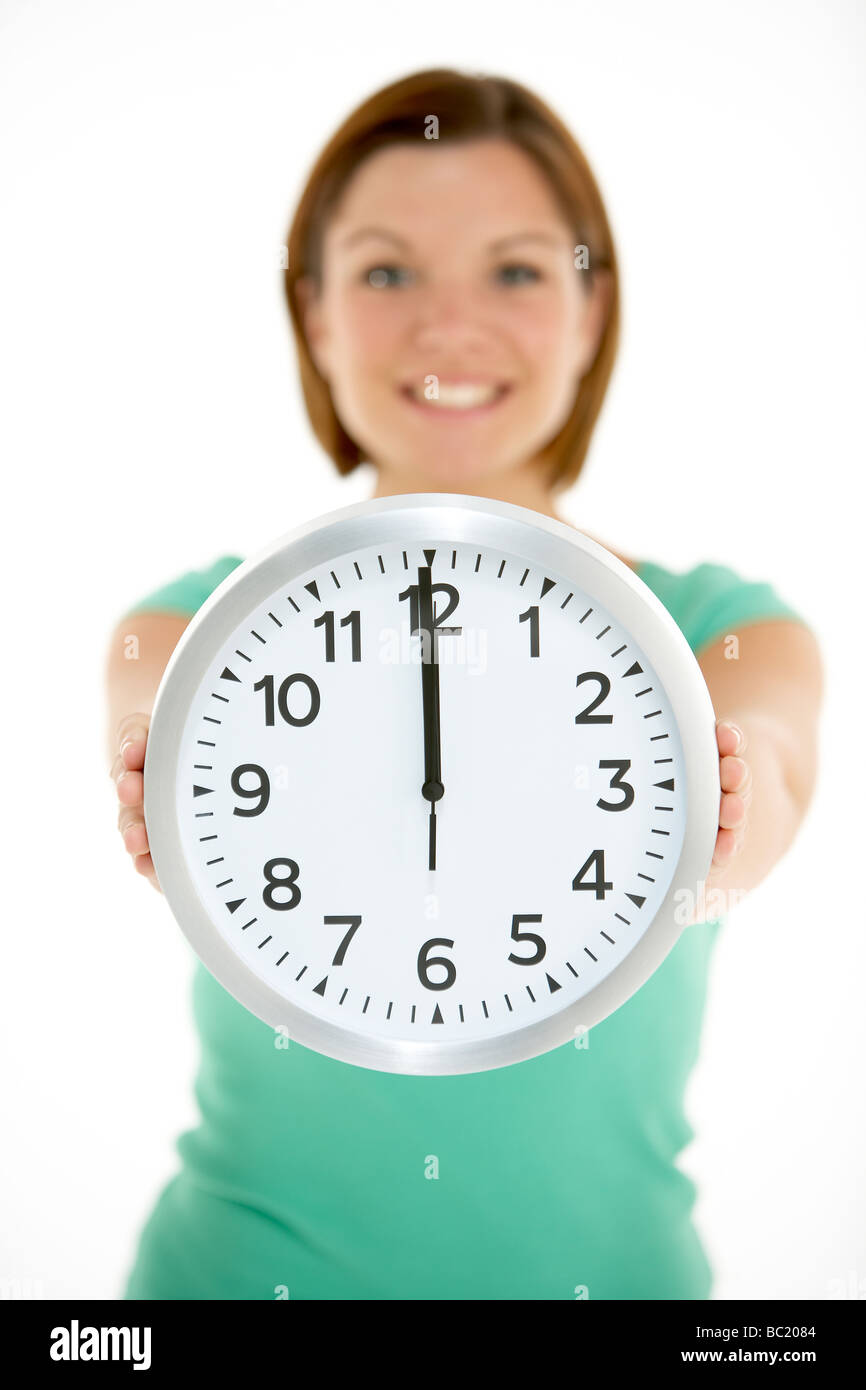 Woman Holding horloge indiquant 12 HEURES Banque D'Images