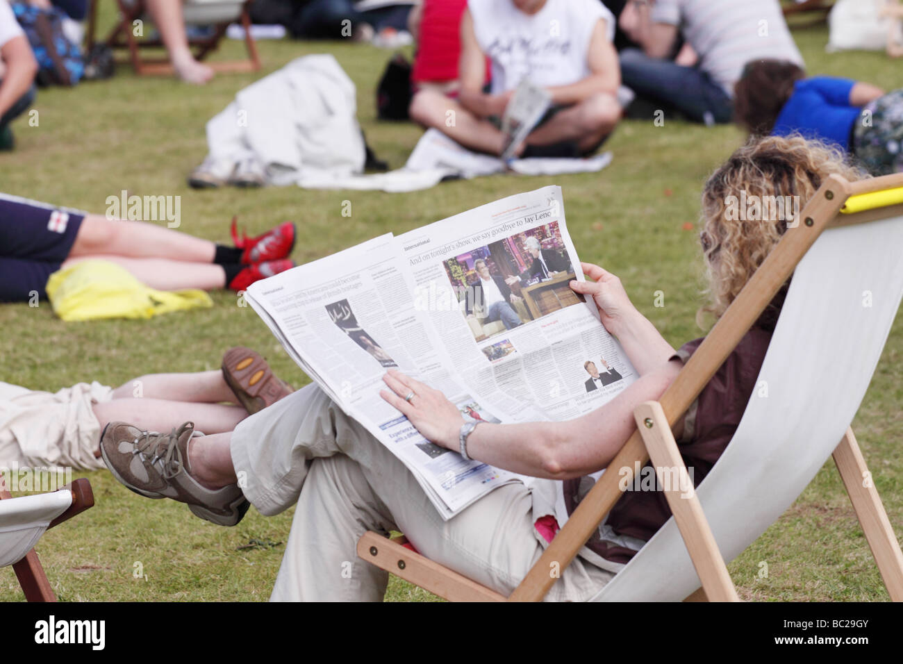 Hay Festival woman lire un journal assis dans une chaise longue sur la pelouse d'herbe à l'Hay Festival Mai 2009 Banque D'Images