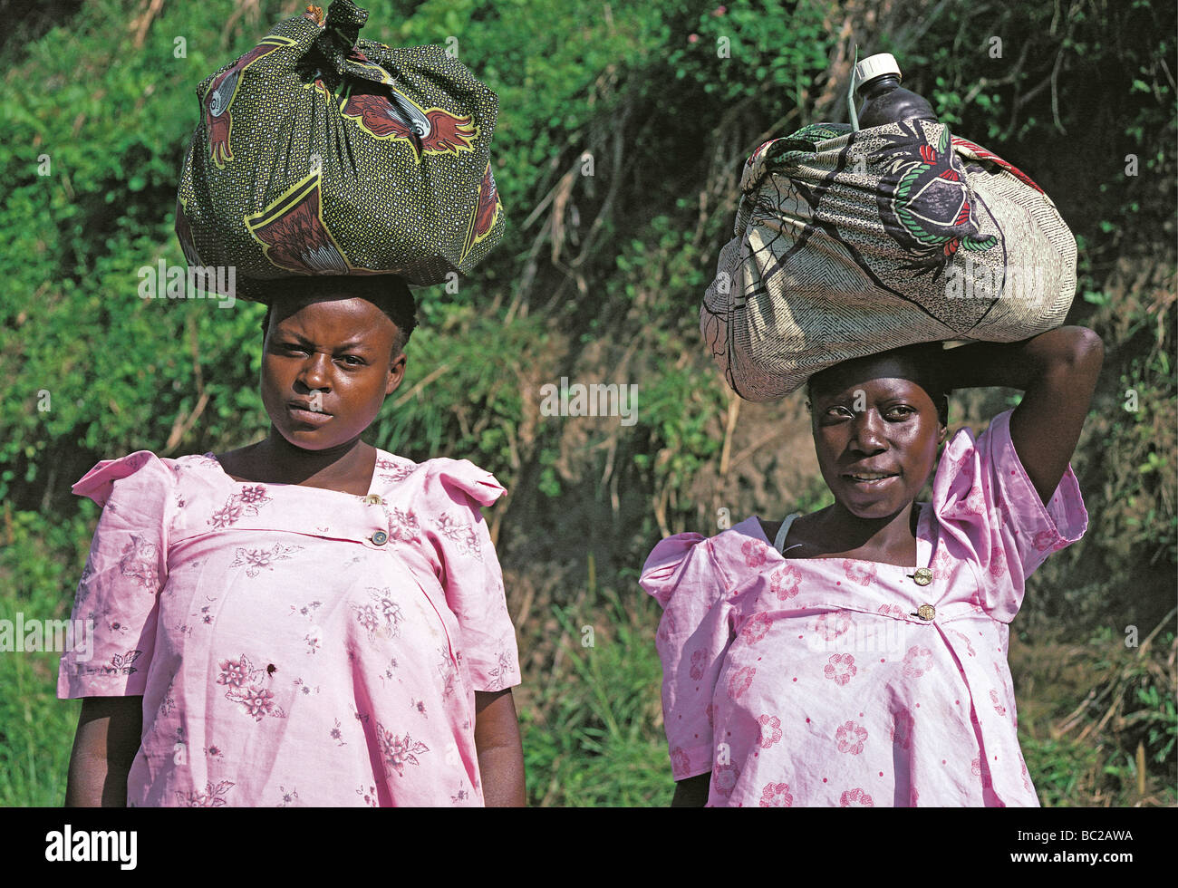 Deux femmes ougandaises avec charges tête près de Kabale en Ouganda du sud-ouest de l'Afrique de l'Est Banque D'Images