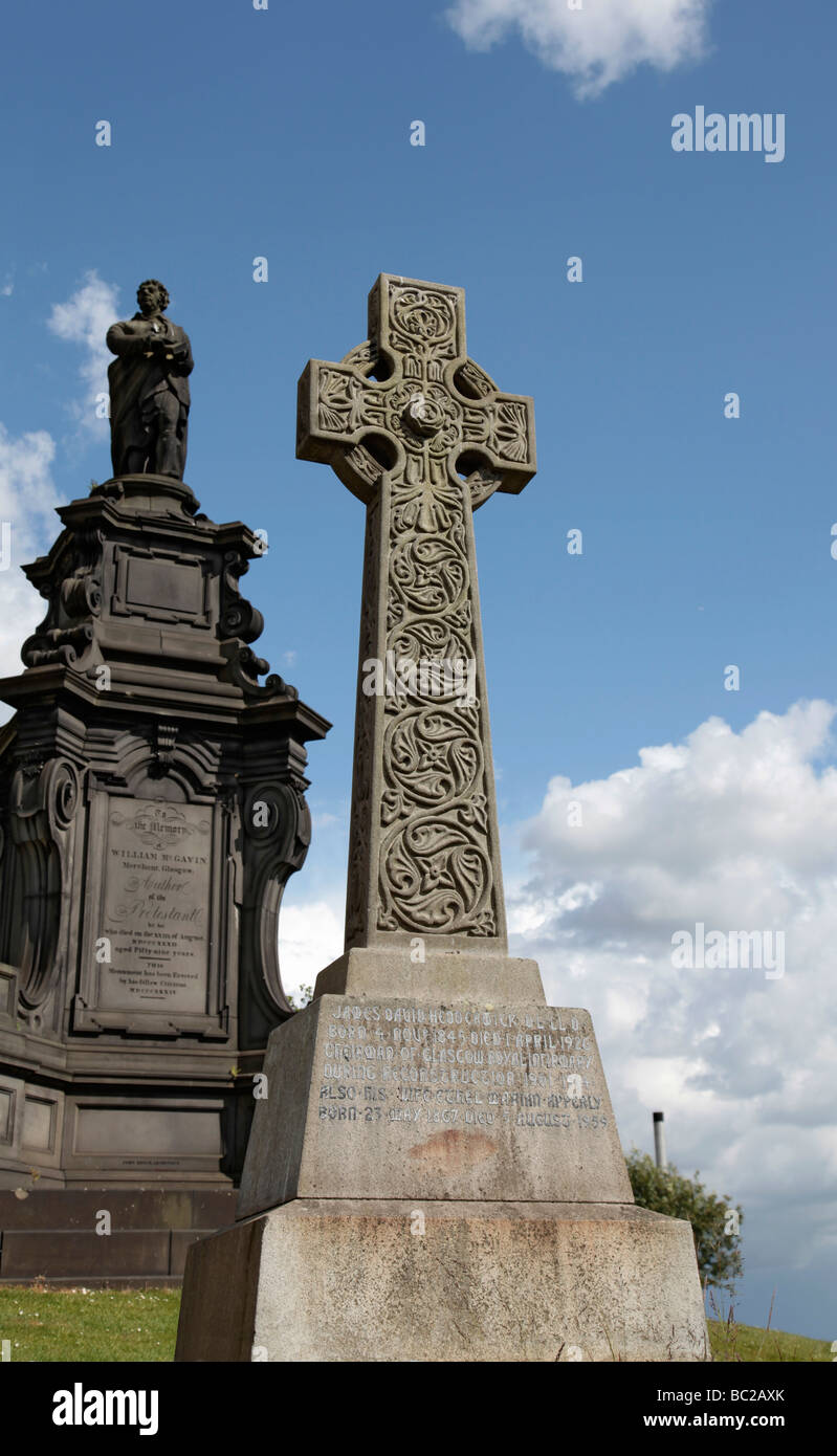 Une croix celtique en pierre de 1926 à côté d'un mémorial officiel daté 1834 à Glasgow's Victorian nécropole. Banque D'Images