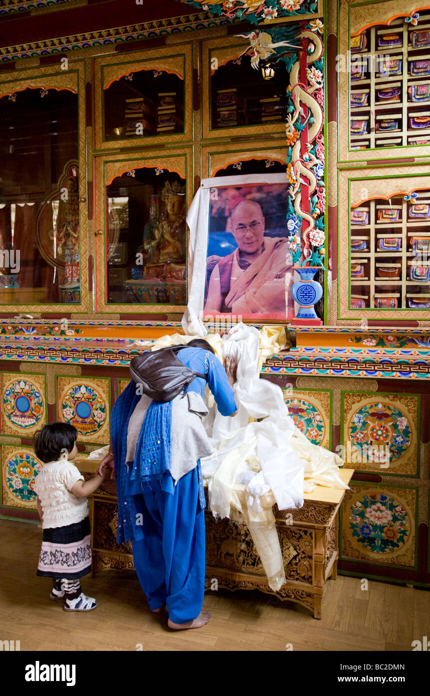 Un ddaughter mère offrant une khata au Dalaï Lama image. Jivatsal temple tibétain. Choglamsar. Près de Leh. Ladakh. L'Inde Banque D'Images