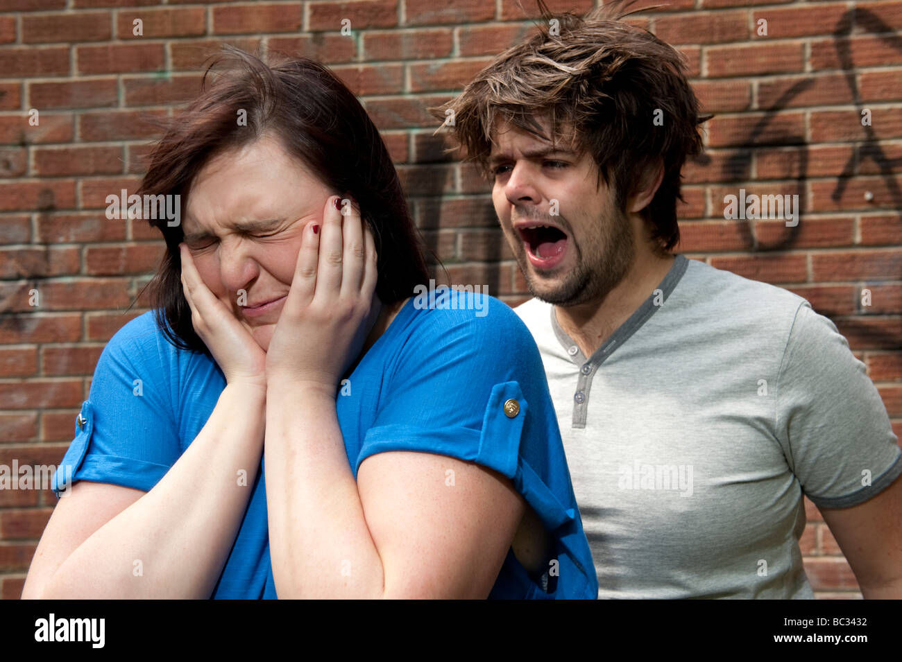 Jeune couple arguing criant la rupture de la relation femme tenant ses mains sur ses oreilles Banque D'Images