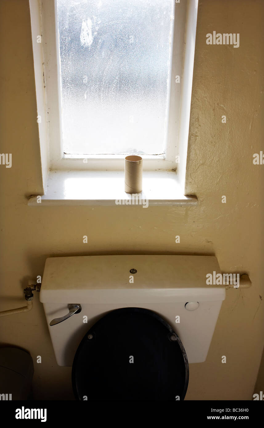 Un rouleau de papier toilette vide dans une salle de bains dans un transport cafe à Cannock, UK. Banque D'Images