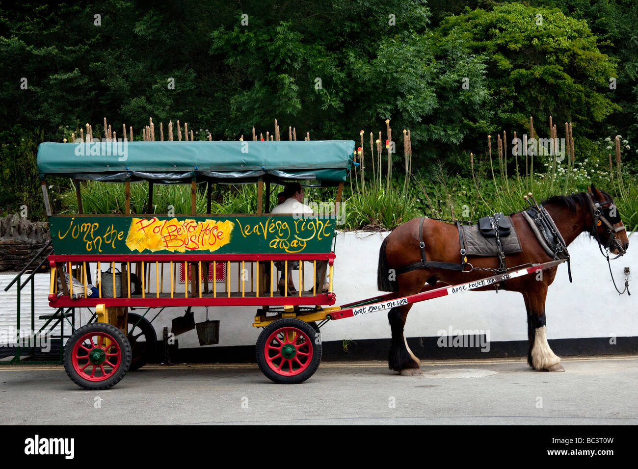 Services de voiturette agricole et de bus lourd du village décoré ; transport public touristique du village à Polperro, Cornouailles, Angleterre du Sud-est, Royaume-Uni Banque D'Images