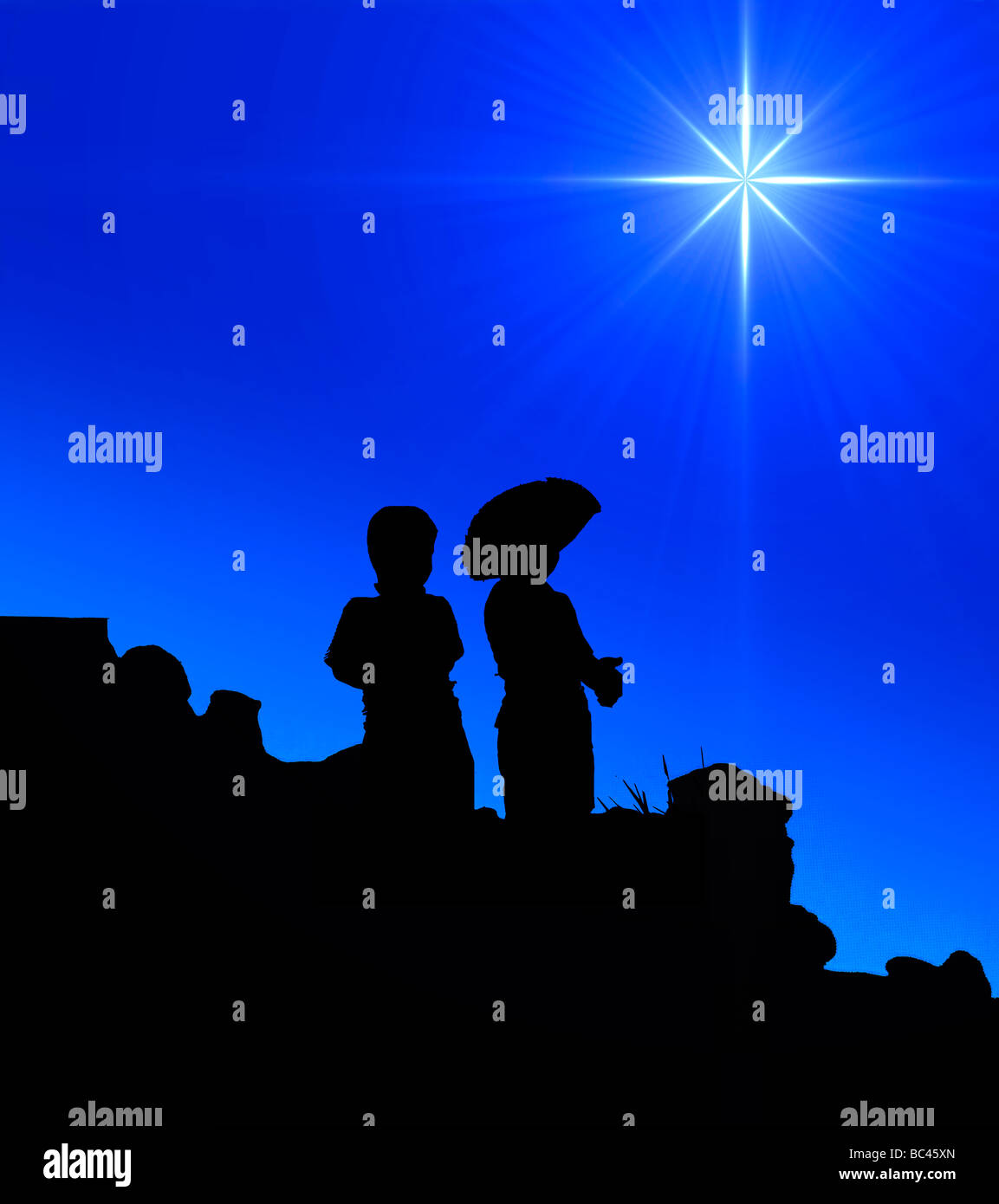 Deux petits garçons se découpant contre le ciel de nuit et étoile du soir Banque D'Images