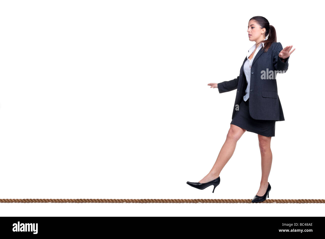 Businesswoman walking le long d'un fil isolé sur fond blanc Banque D'Images