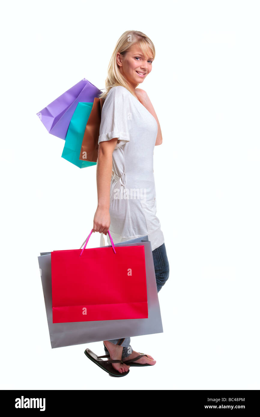 Blonde woman carrying shopping bags colorés isolé sur fond blanc Banque D'Images