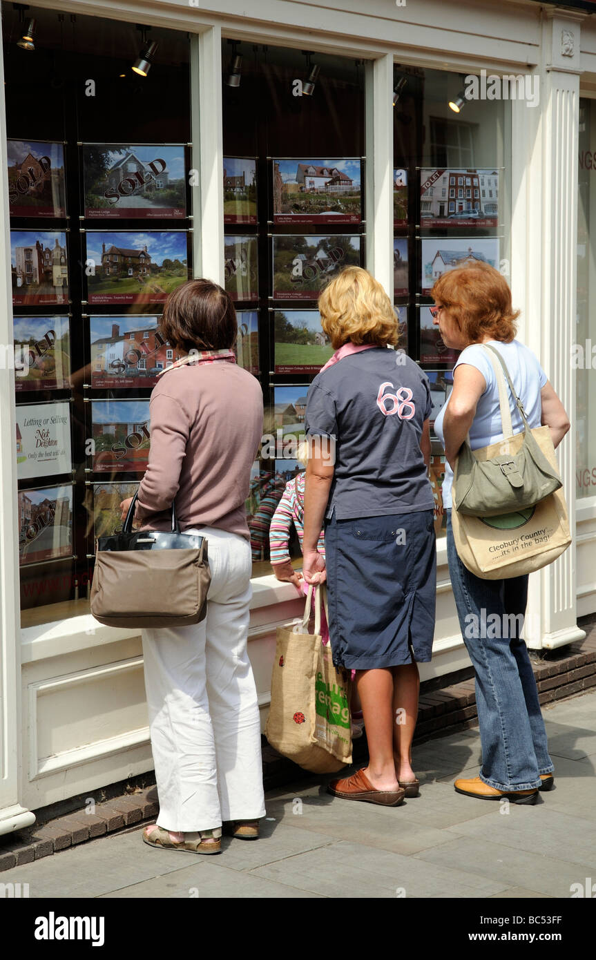 Les femmes à la maison de ventes dans une fenêtre d'agents immobiliers Ludlow Shropshire England UK Banque D'Images