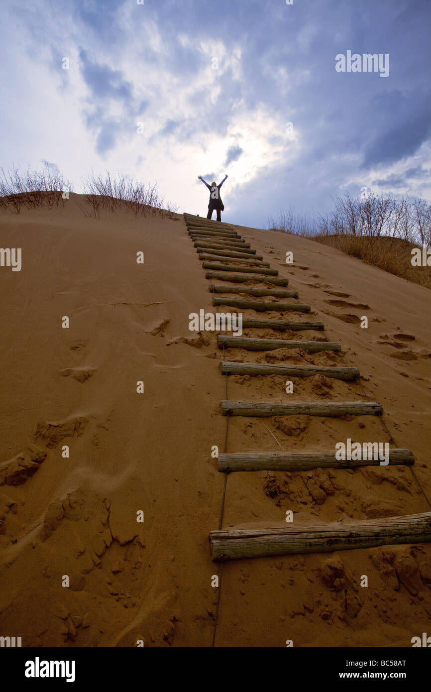 Femme célèbre son monter une dune de sable, Spirit Sands, parc provincial de Spruce Woods, au Manitoba, Canada. Banque D'Images