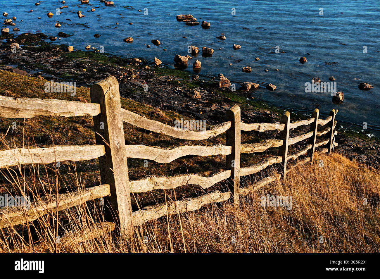 Fence menant jusqu'à la rive sur l'île de Lindisfarne (saints) Banque D'Images