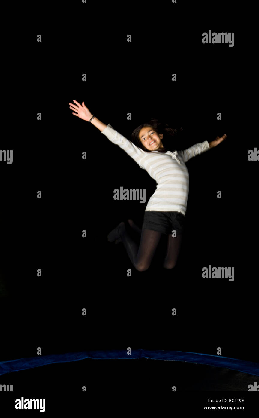 Teenager jumping on trampoline night Banque de photographies et d'images à  haute résolution - Alamy