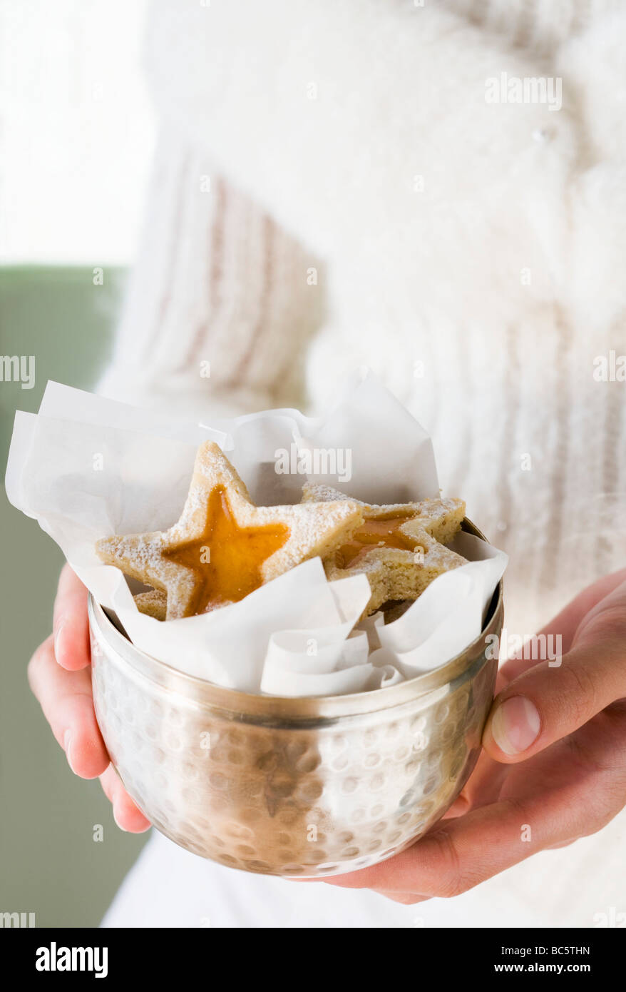 Mains tenant dans des biscuits confiture - coupe en argent Banque D'Images