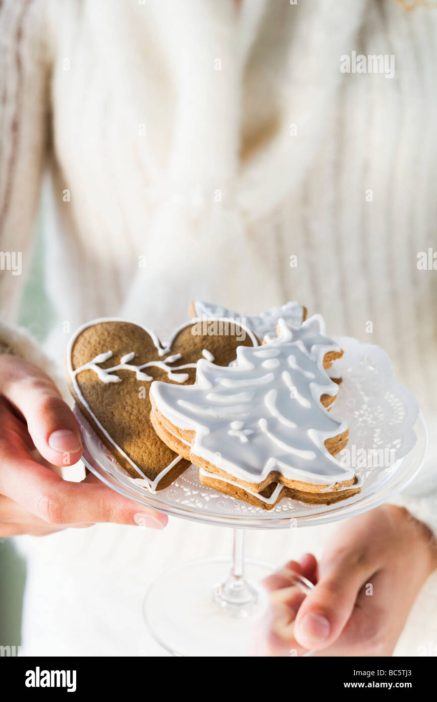 Mains tenant bol en verre d'assortiment d'épices Biscuits - Banque D'Images