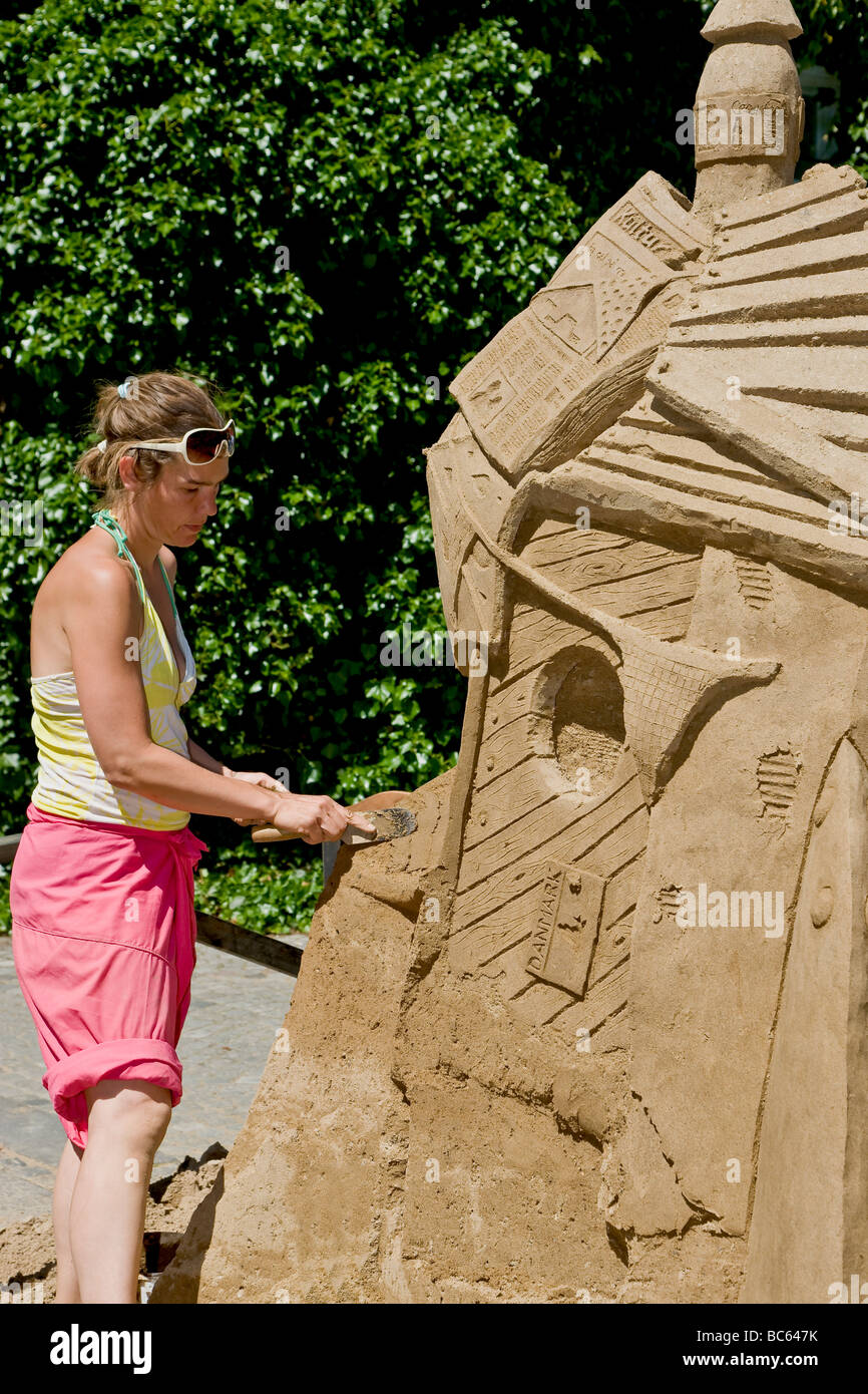 Un artiste féminine la construction d'une sculpture de sable Banque D'Images