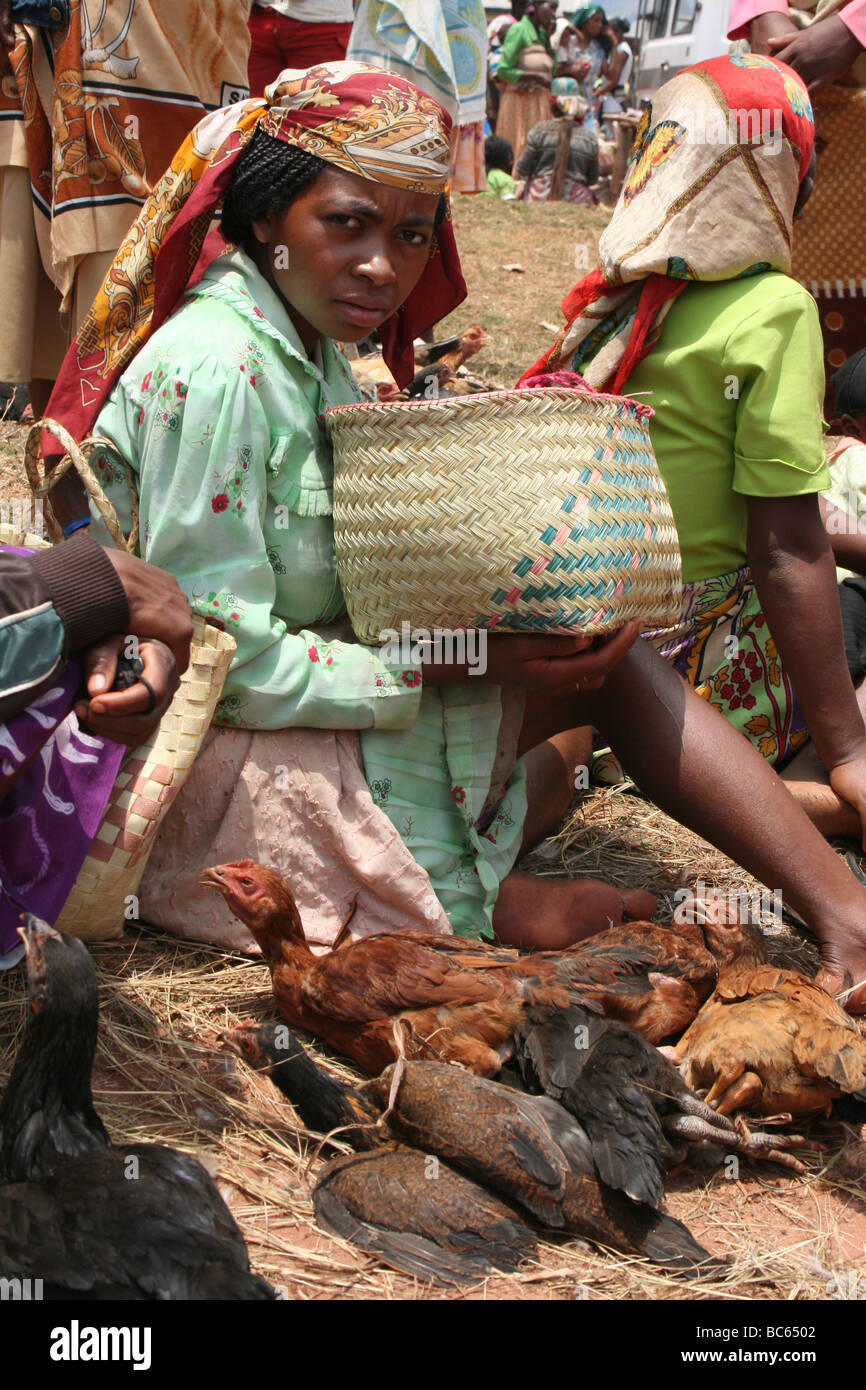 Femme vendant des poulets dans un marché rural au Camp Robin, province de Fianarantsoa, Madagascar Banque D'Images