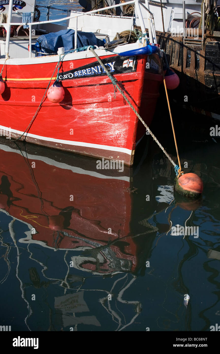 L'arc peint en rouge de navires de pêche, la sérénité se reflète dans l'eau de Roker marina à Sunderland, Angleterre, RU Banque D'Images