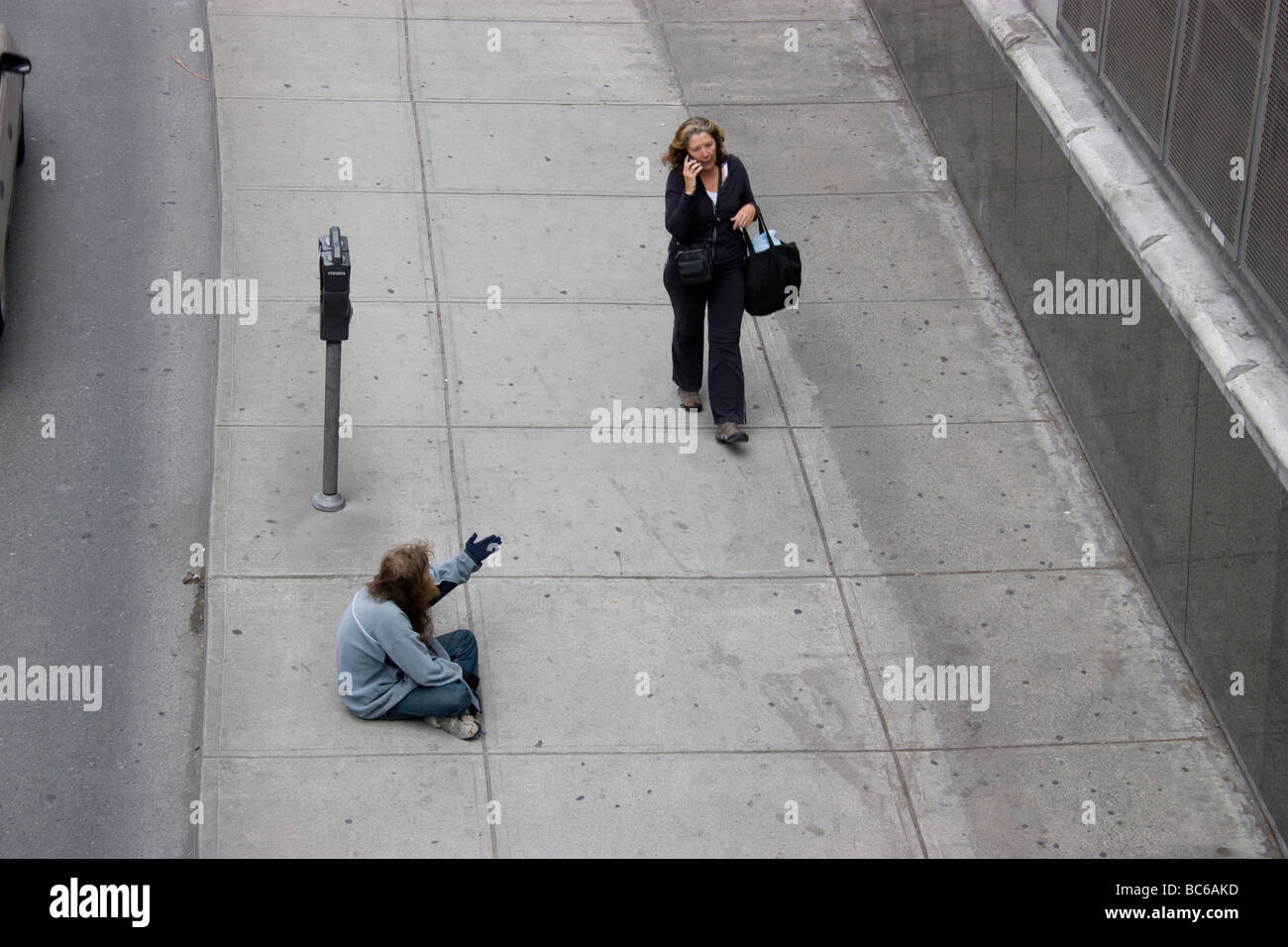 Riches pauvres inégalités de division, Vancouver Canada sans-abri vagabond vagabond gastown mendiant pour de l'argent des touristes, avec la femme passant sur le téléphone mobile Banque D'Images