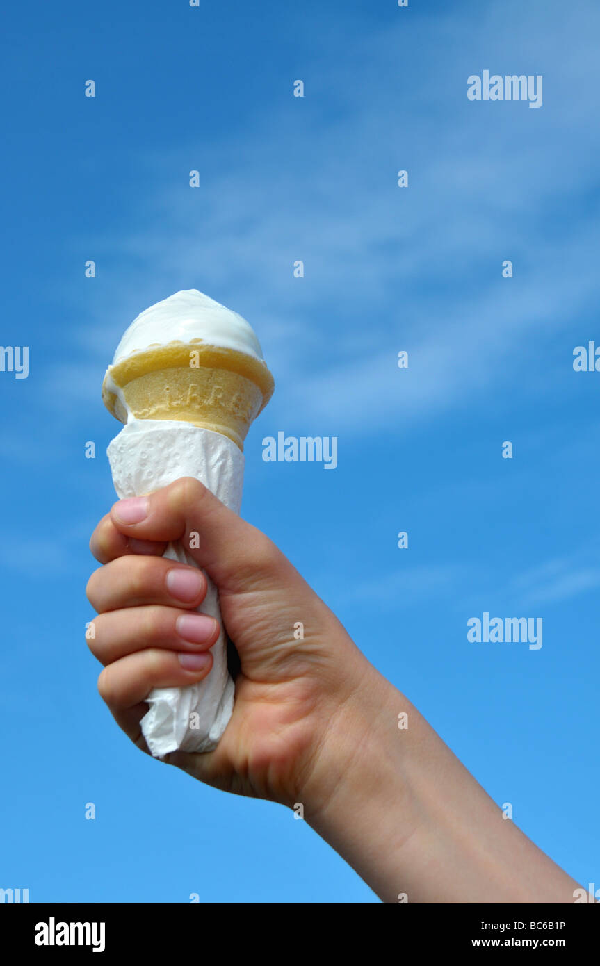 Un jeune garçon tenant son cornet de crème glacée. Banque D'Images