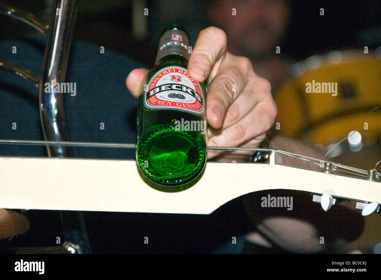 Fils Henry jouant la lap steel guitar avec une bouteille de bière Becks vide pendant la performance live Blues bonanza à Dundee Banque D'Images