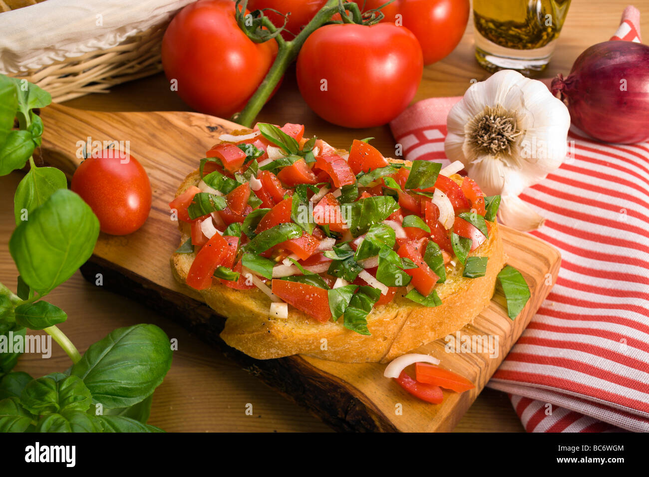 Pain bruschetta italienne servi sur planche en bois d'olive, décoré avec divers ingrédients Banque D'Images