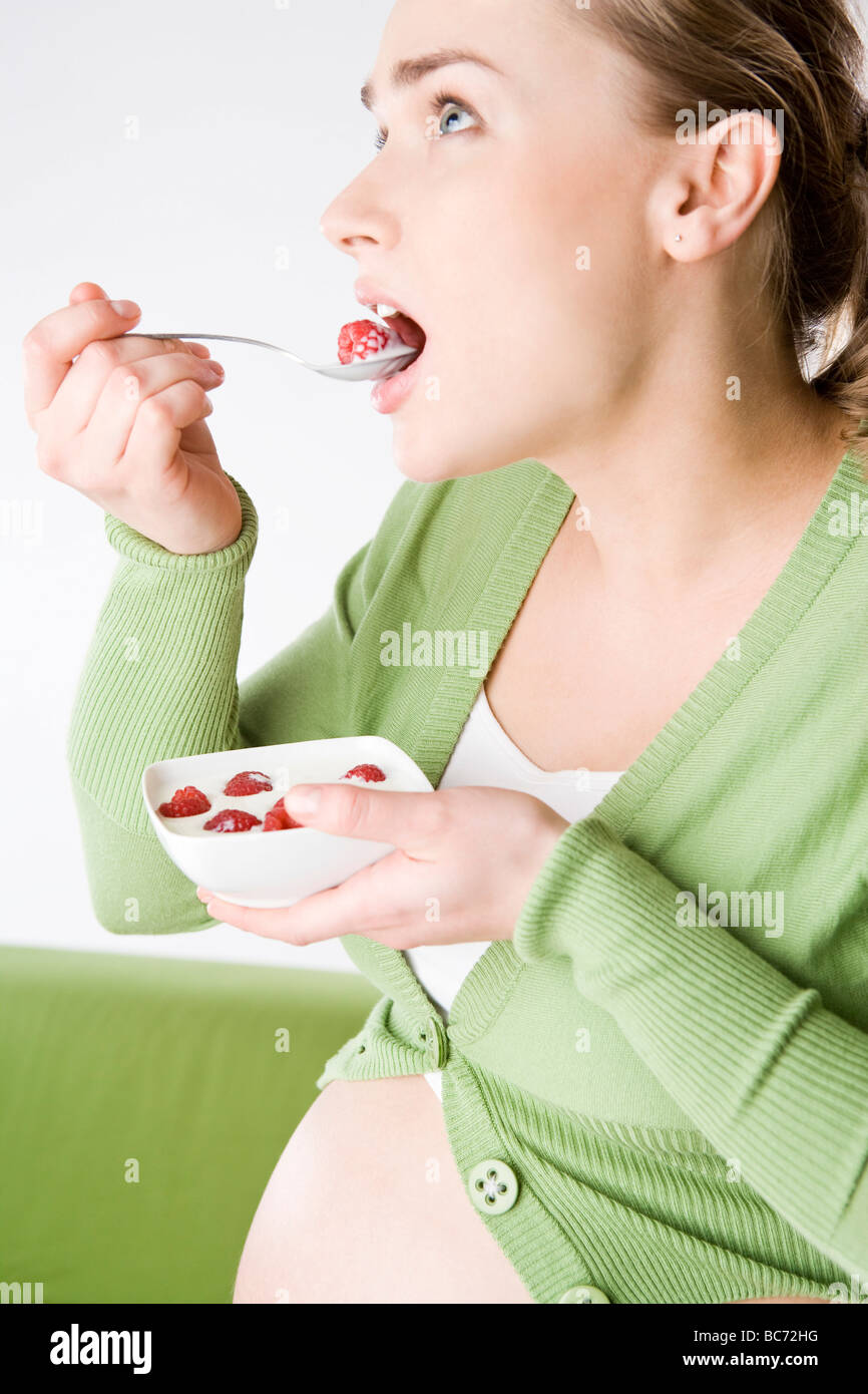 Femme enceinte de manger du yogourt aux framboises Photo Stock - Alamy