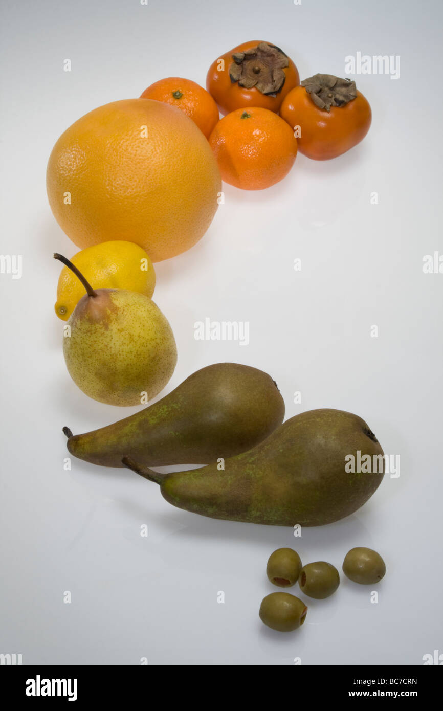 Tri des fruits progressivement par la couleur. Olives, poires, citron, mandarine, orange kaki fruit. Fond blanc studio shot. Banque D'Images