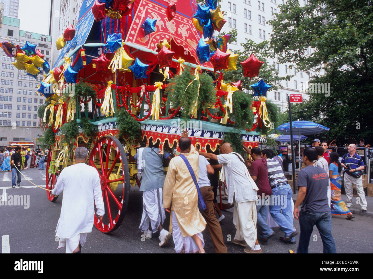 Défilé du festival Hare Krishna de New York et ses adeptes poussent le flotteur coloré avec des ballons sur les gens de la Cinquième Avenue dans la rue de New York City USA Banque D'Images