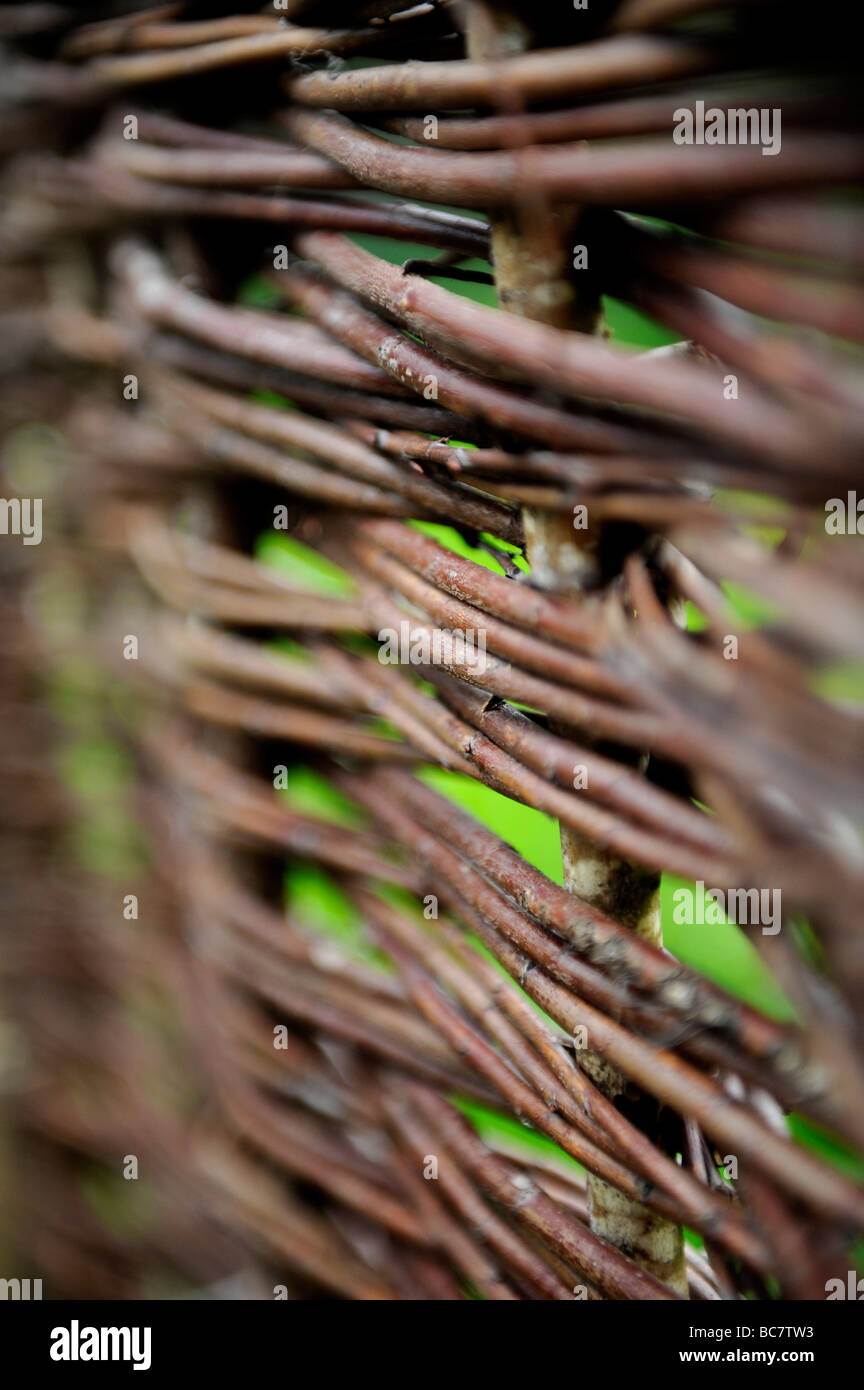 Un gros plan de la texture sur un fait main marron noisette tissé clôture dans un jardin biologique Banque D'Images