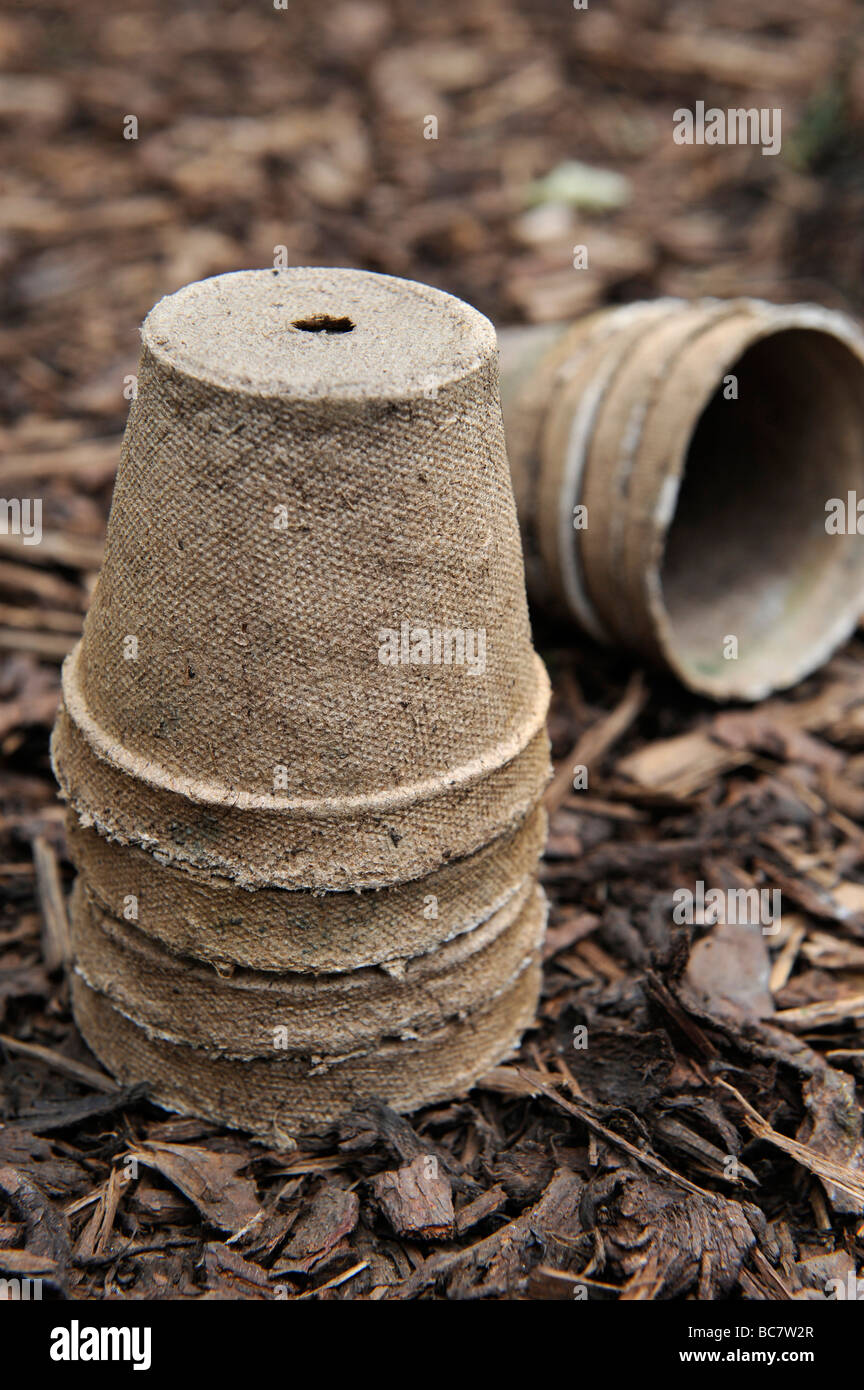 Re utilisé des pots de semences compostables brun écorce empilés sur des gravillons dans un jardin biologique Banque D'Images