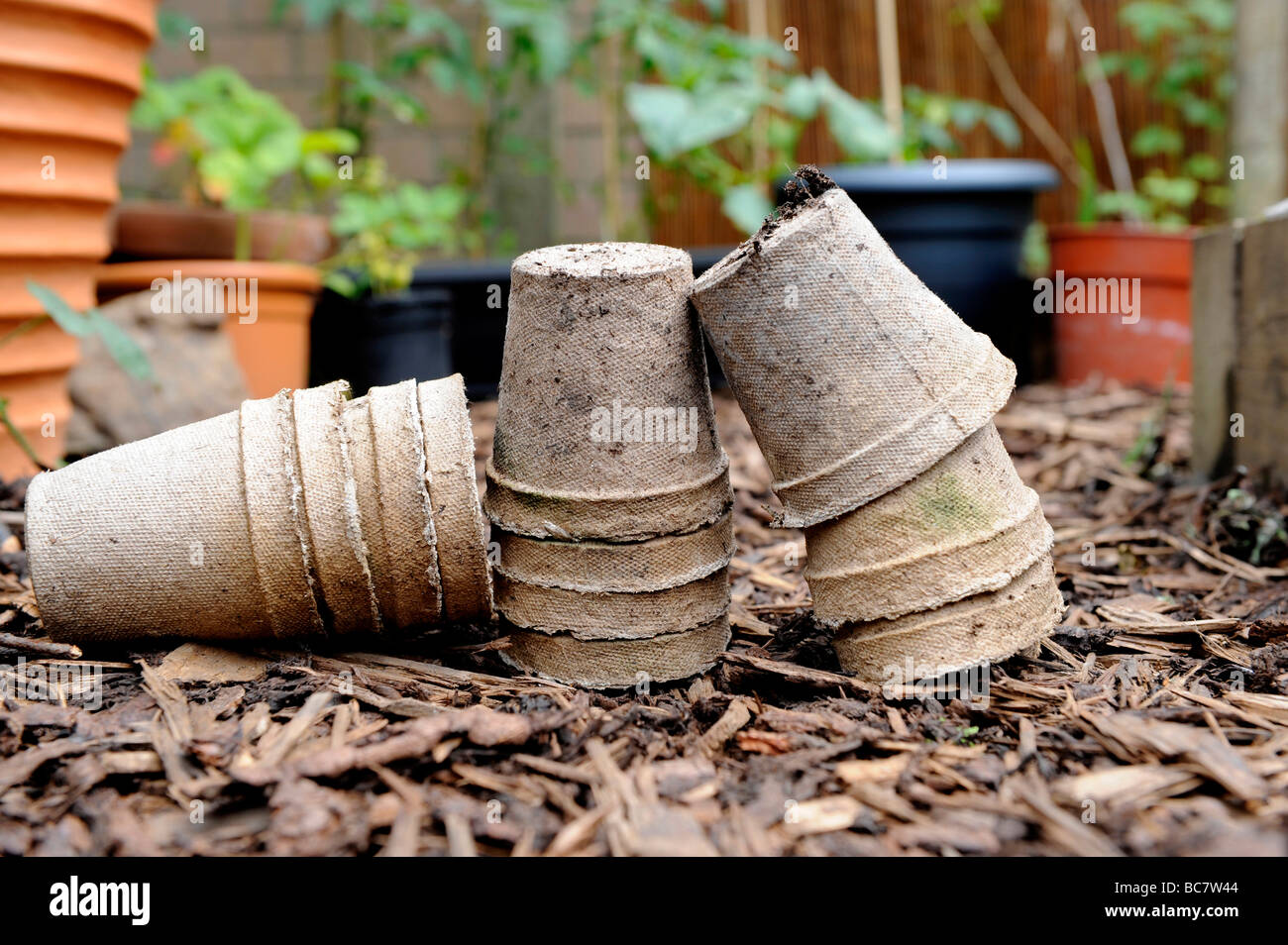 Re utilisé des pots de semences compostables brun écorce empilés sur des gravillons dans un jardin biologique Banque D'Images