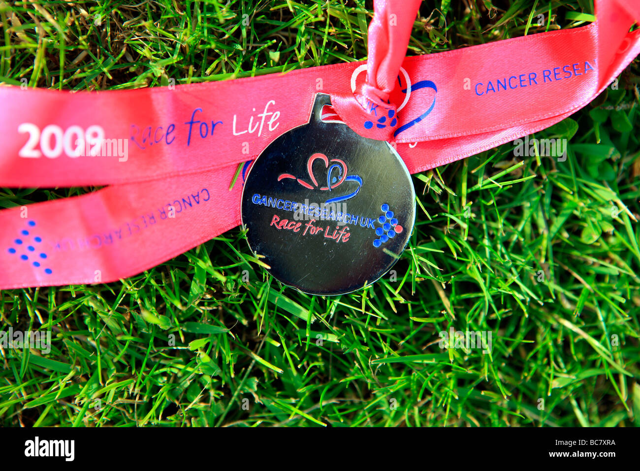 Course à la médaille de la vie lying on grass Banque D'Images Course à la médaille de la vie lying on grass Banque D'Images