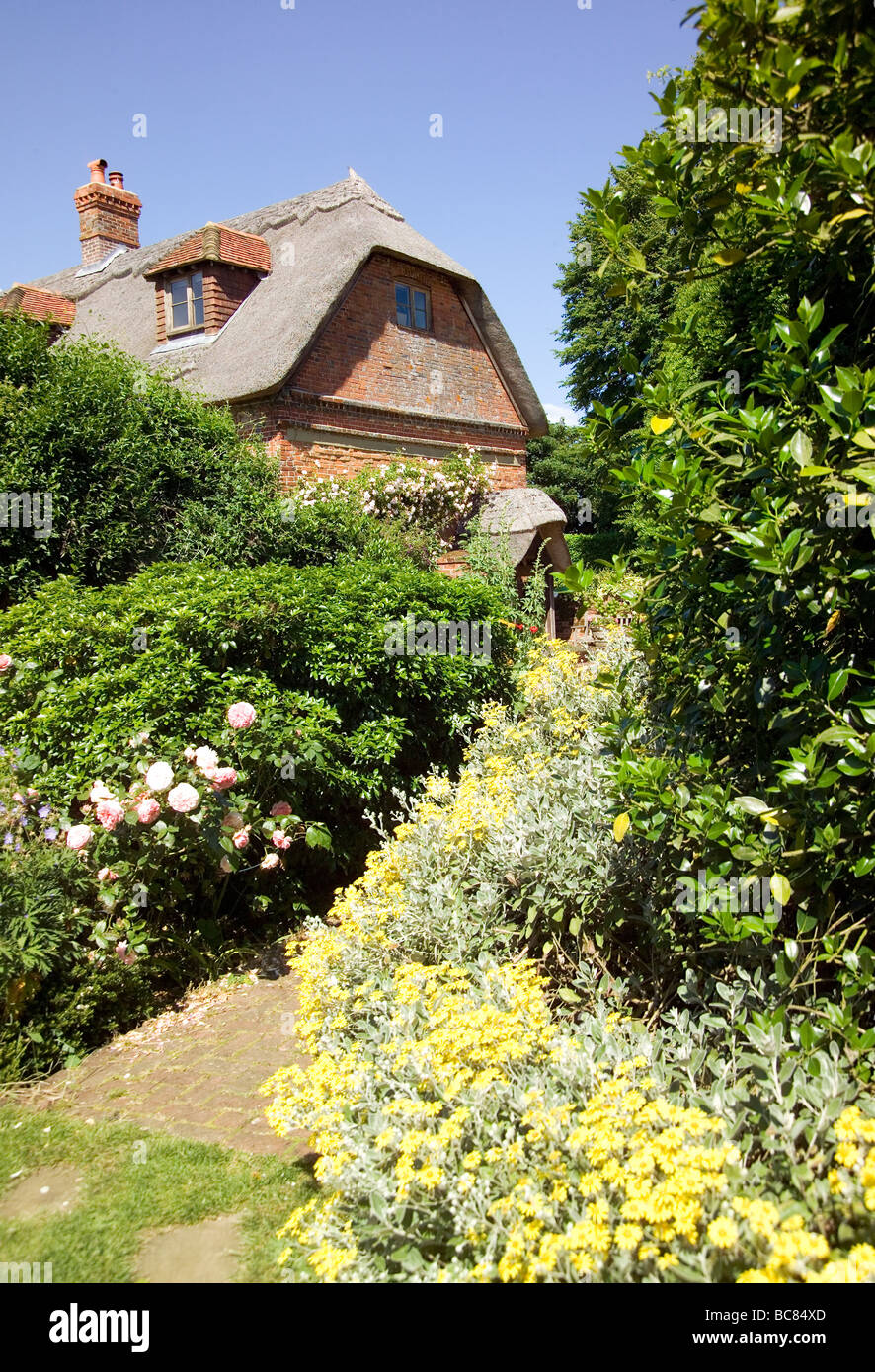 Joli jardin anglais avec Thatched Cottage Banque D'Images