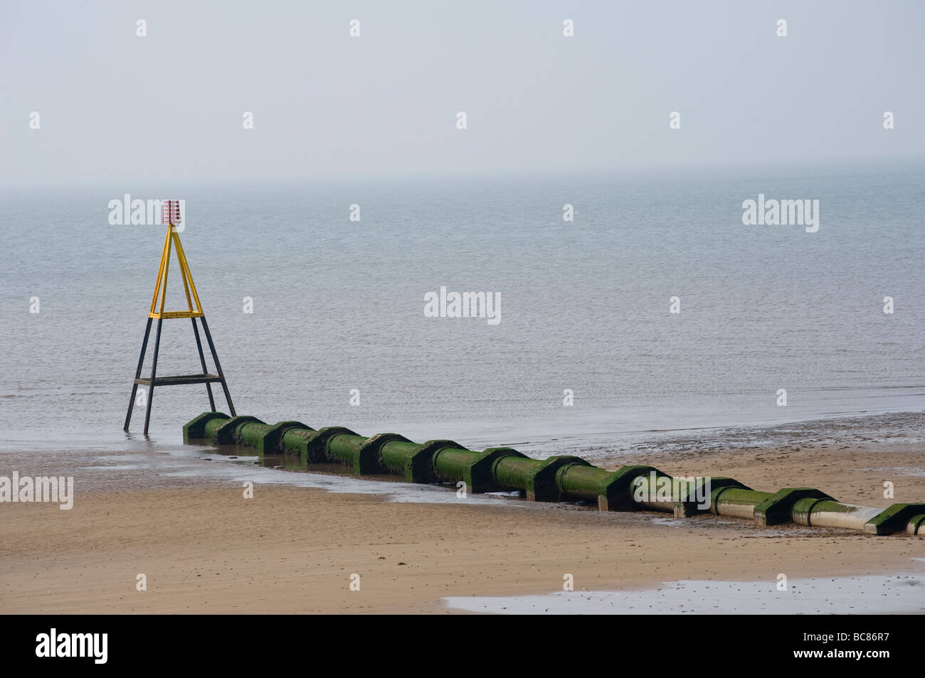 Sortie d'égout tuyau relié à une plage de la mer en Angleterre Banque D'Images