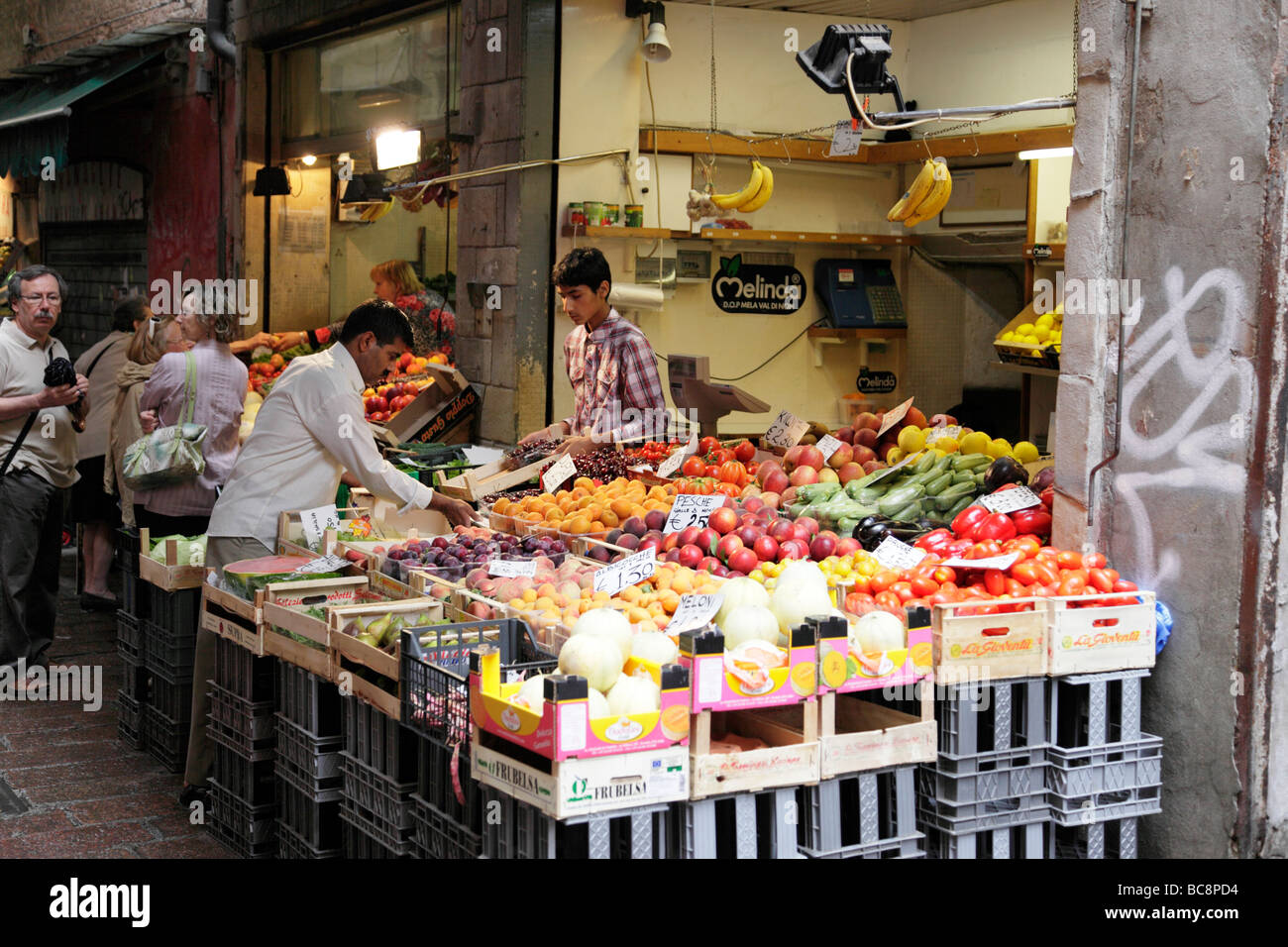Des étals de fruits et légumes dans la rue étroite de la via pescherie vecchie Bologna Italie Banque D'Images