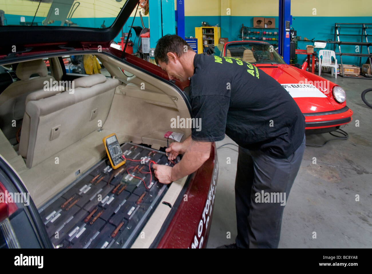 Un technicien à une modification de véhicule de la Californie du Sud shop vérifie la tension d'une voiture hybride Toyota Prius Banque D'Images