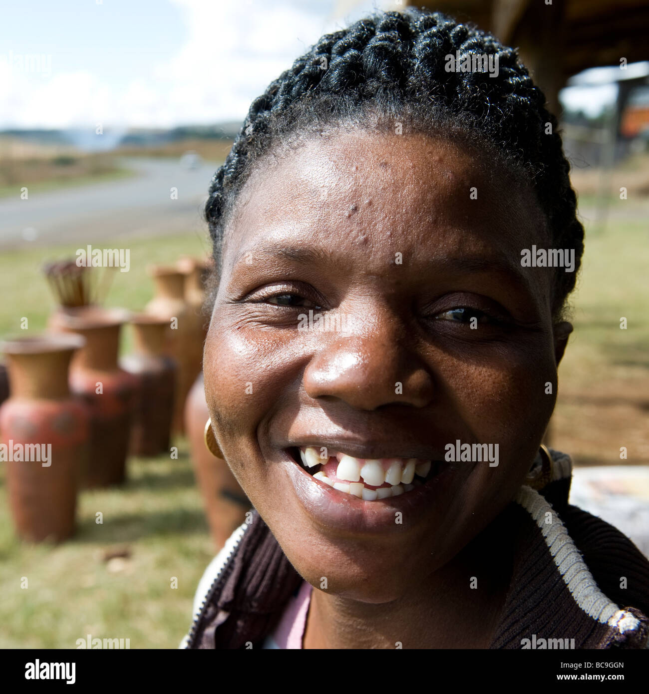 De grands sourires de bienvenue dans le monde merveilleux de Mpumalanga Région du patrimoine d'une belle femme sud-africaine Vente de poterie. Banque D'Images