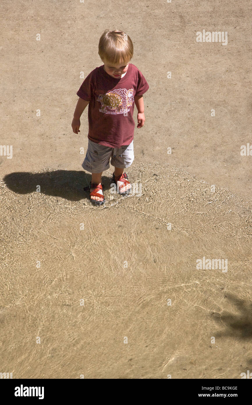 Enfant jouant dans la rivière Arkansas le long d'une passerelle en Salida Colorado USA Banque D'Images